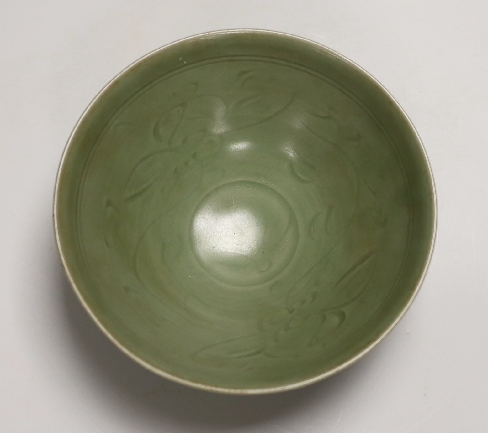 A Chinese celadon ground ‘lotus’ bowl, 21cm diameter